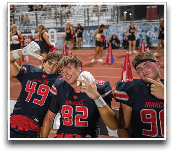 Three football players are standing on the field, one of them is smiling and wearing a black jersey with the number 55. AI generated content