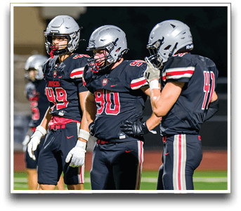 Three football players are standing on the field, one of them is smiling and wearing a black jersey with the number 55. AI generated content