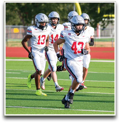 Three football players are standing on the field, one of them is smiling and wearing a black jersey with the number 55. AI generated content