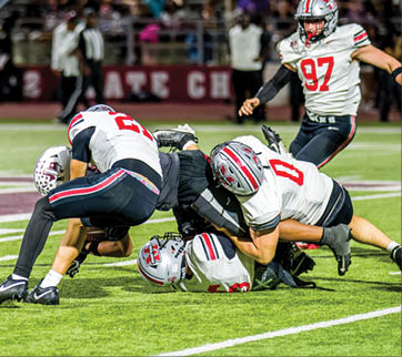 Three football players are standing on the field, one of them is smiling and wearing a black jersey with the number 55. AI generated content