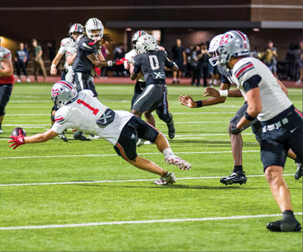 Three football players are standing on the field, one of them is smiling and wearing a black jersey with the number 55. AI generated content