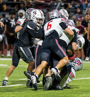 Three football players are standing on the field, one of them is smiling and wearing a black jersey with the number 55. AI generated content