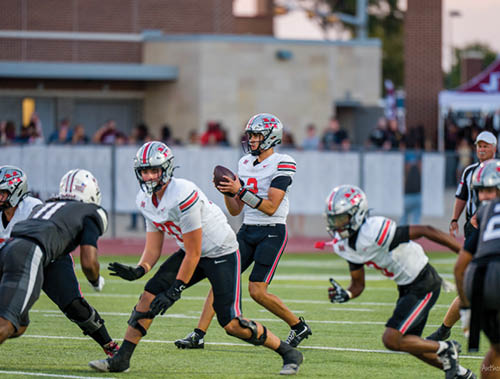 Three football players are standing on the field, one of them is smiling and wearing a black jersey with the number 55. AI generated content
