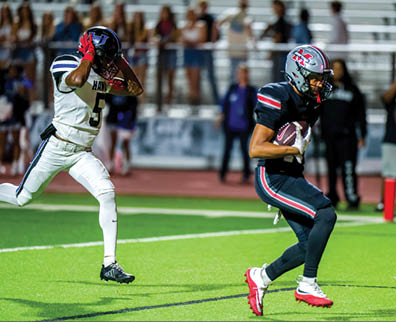 Three football players are standing on the field, one of them is smiling and wearing a black jersey with the number 55. AI generated content