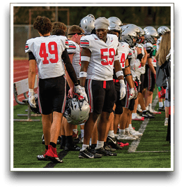 Three football players are standing on the field, one of them is smiling and wearing a black jersey with the number 55. AI generated content