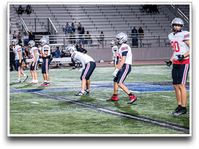 Three football players are standing on the field, one of them is smiling and wearing a black jersey with the number 55. AI generated content
