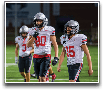 Three football players are standing on the field, one of them is smiling and wearing a black jersey with the number 55. AI generated content