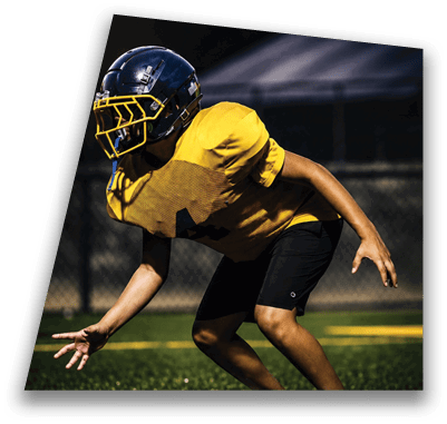 A football player in a yellow jersey is crouching on the field, wearing a helmet and ready to catch the ball. AI generated content