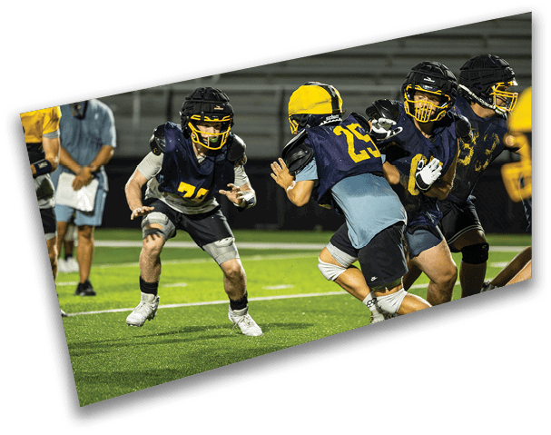 A group of football players on a field, with one player in the foreground wearing a yellow jersey. AI generated content