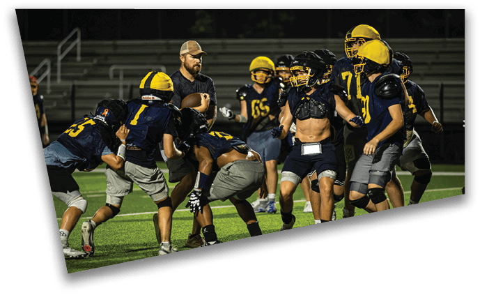A group of football players huddled together on the field, wearing helmets and uniforms. AI generated content