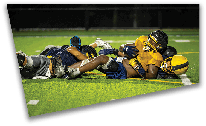 A group of football players are lying on the ground, resting on a field. AI generated content