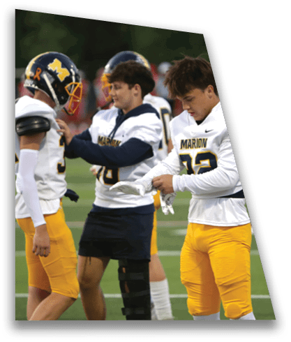 A group of young men wearing football uniforms are standing on a field. One of the players is holding a towel and looking at his watch. AI generated content