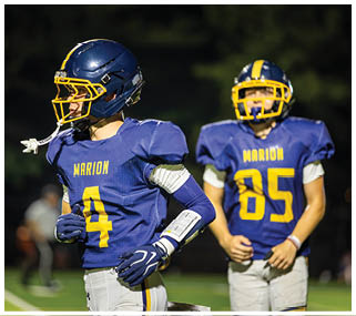 Two football players wearing blue uniforms with the number 4 and 85 on the back. AI generated content
