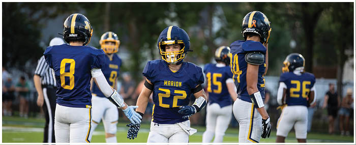 A group of football players are on the field, with one player wearing a blue jersey with the number 22. AI generated content