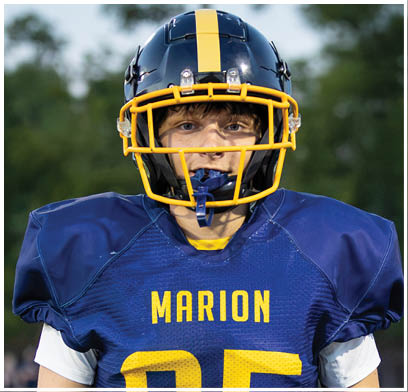 A football player wearing a blue and yellow jersey stands on the field. AI generated content