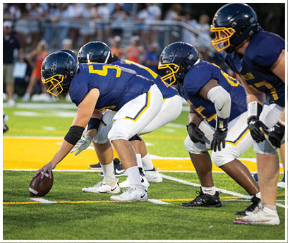 A football game is in progress with a player holding a football. AI generated content