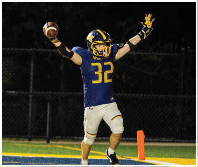 A football player wearing a blue jersey with the number 32 celebrates after scoring a touchdown. AI generated content