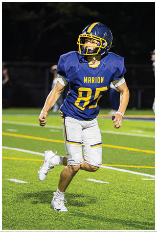A football player in a blue jersey is running on the field. AI generated content
