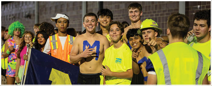 A group of people wearing neon yellow shirts and holding a flag with the letters M and H on it. AI generated content