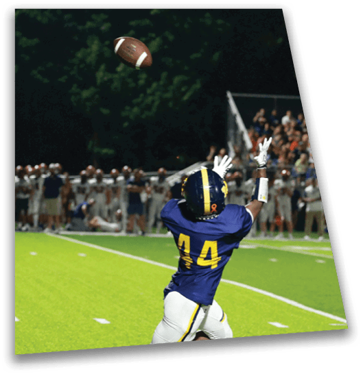 A football player in a blue jersey with the number 44 on it catching a football. AI generated content