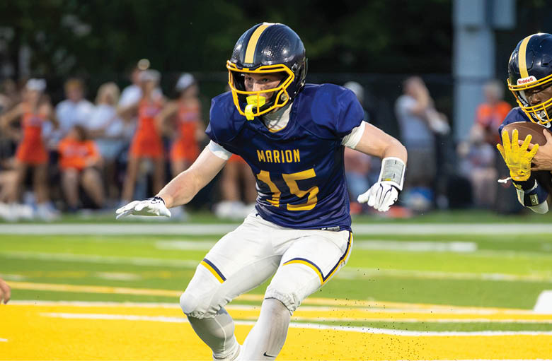 Two football players from opposing teams are running towards a ball on the field. AI generated content