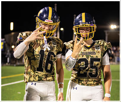 Two football players pose for a picture on the field. AI generated content