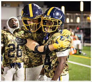 Two football players hugging each other on the field. AI generated content