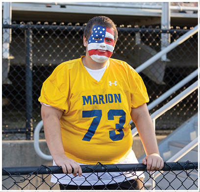 A man wearing a yellow jersey with the number 73 stands on a field. AI generated content