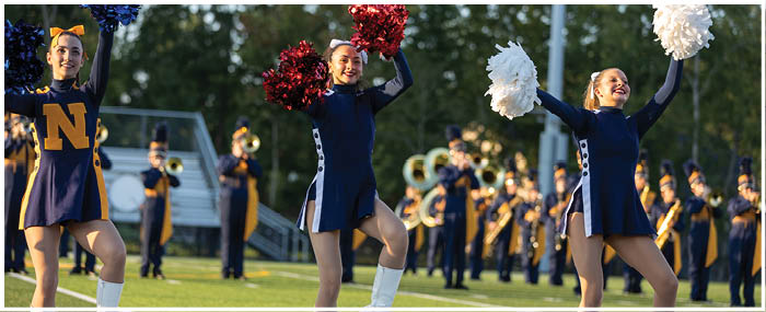 A group of cheerleaders are performing on a field. AI generated content