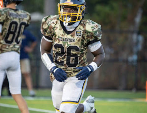 A football player wearing a camouflage jersey with the number 26 on the back is running on the field. AI generated content