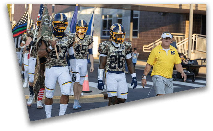 A group of football players in camouflage uniforms are walking down a street. AI generated content