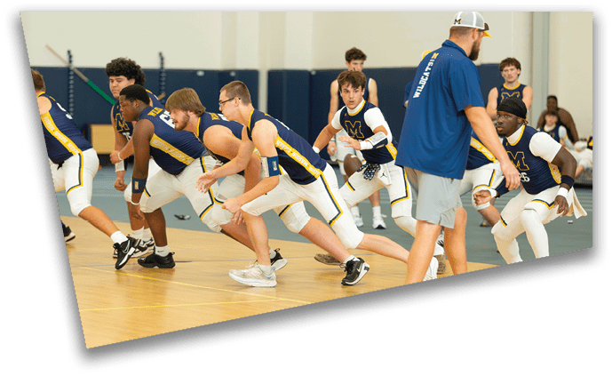 A group of adults in athletic uniforms are stretching and warming up on an indoor basketball court while a coach in sportswear observes. Description generated by AI