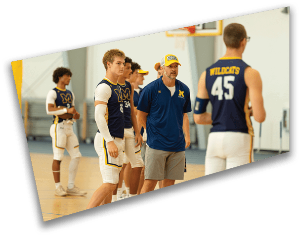 Adults wearing basketball uniforms and a coach in a gym appear to be listening or preparing for practice. Description generated by AI