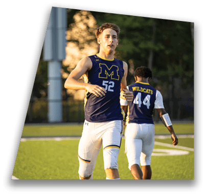 Two people wearing sports uniforms with numbers are on a field, one running toward the camera and the other walking away. Description generated by AI
