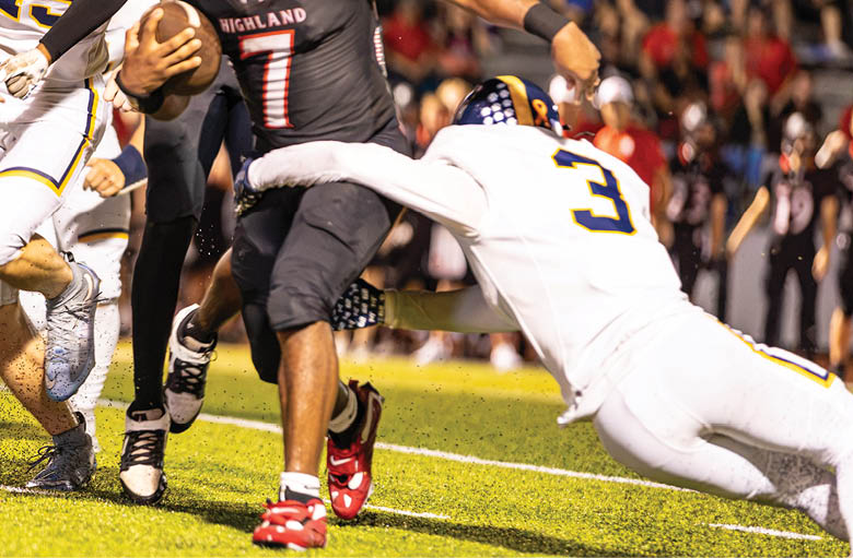 People in sports uniforms are actively running on a grassy field during a football game. Description generated by AI