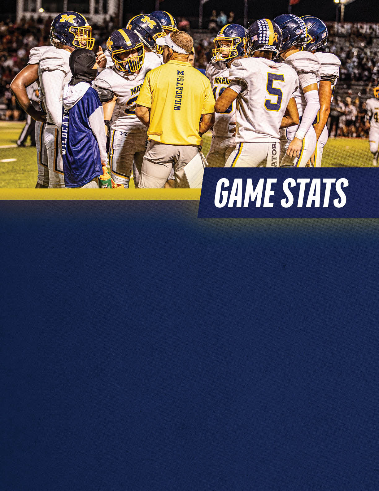 A group of football players in helmets and uniforms are gathered around a coach wearing a yellow shirt on a lit field with a “GAME STATS" banner below them. Description generated by AI