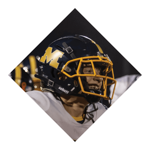 A person wearing a white sports jersey with the number 85 and the word Marion is on a field with others in yellow sports uniforms. Description generated by AI