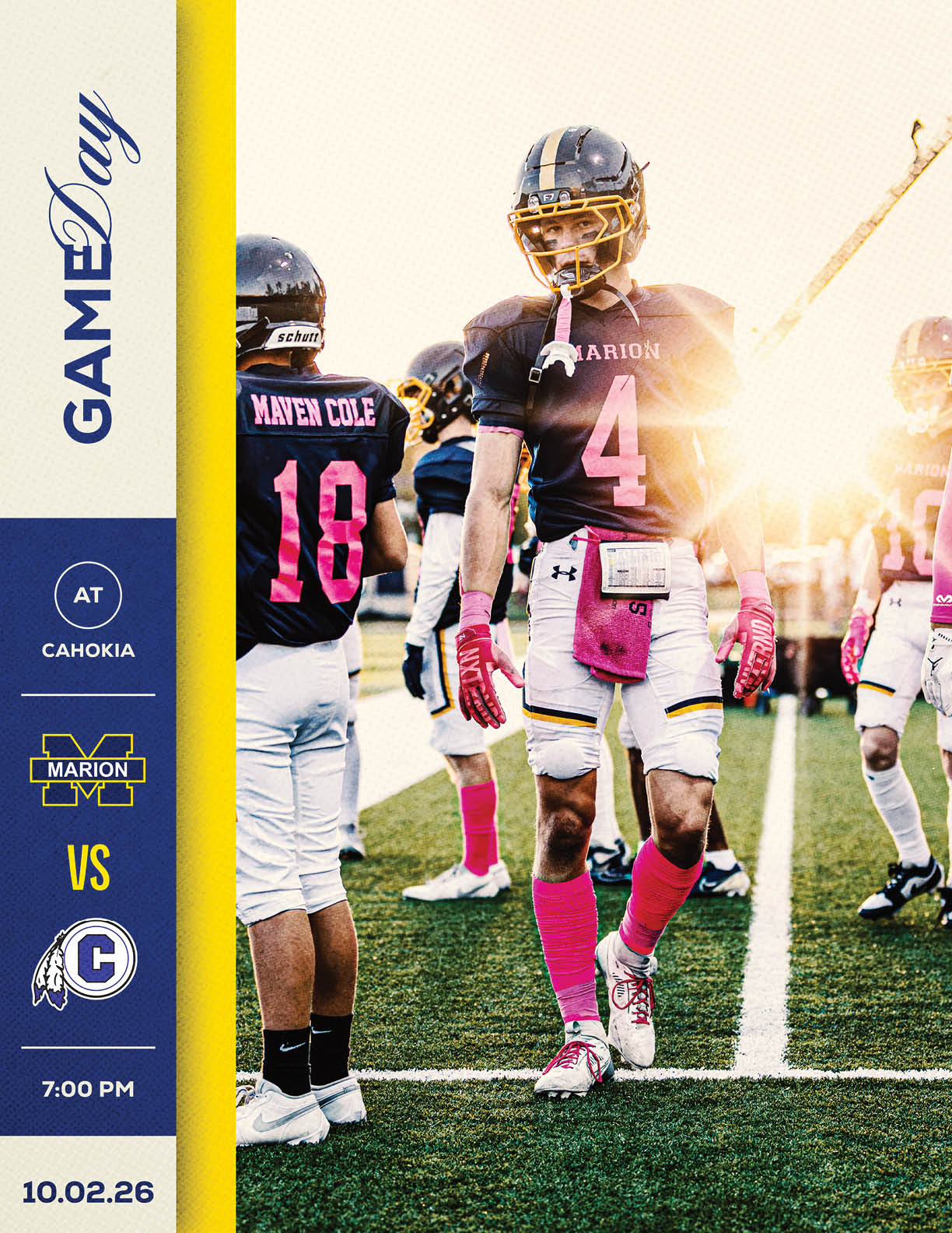 Football players in black and pink uniforms stand on a field during a game at Cahokia with the sun setting in the background. Description generated by AI