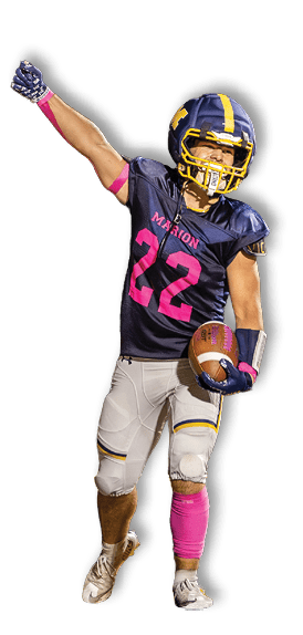A person wearing a dark football uniform with pink accents and the number 22 is holding a football and raising one arm in celebration on a field. Description generated by AI