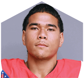 Person wearing a red sports jersey with a focused expression against a plain background. Description generated by AI