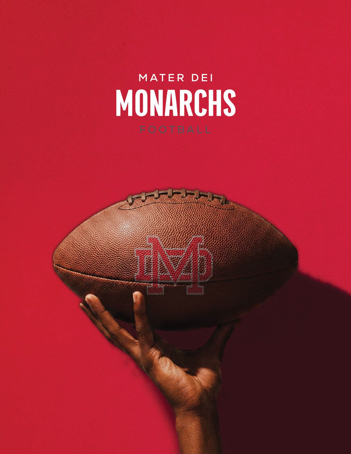A hand is holding a football with the Mater Dei Monarchs logo against a red background with the words Mater Dei Monarchs Football above. Description generated by AI