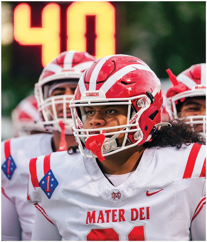 Two people wearing red and white helmets are in front of a blurred scoreboard displaying the number 40. Description generated by AI