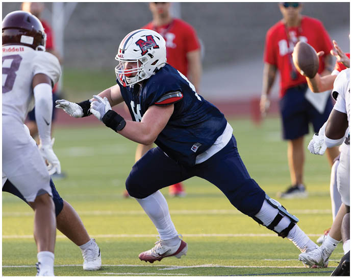 A football player wearing a blue and white uniform. Description generated by AI