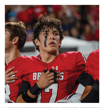 A football player wearing a blue and red jersey. Description generated by AI