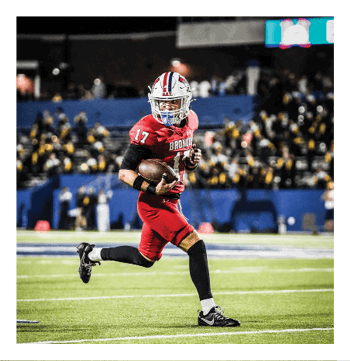 A football player wearing a blue and red jersey. Description generated by AI