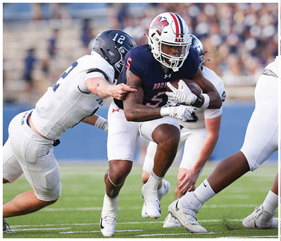 A football player running on the field. Description generated by AI