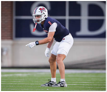 A football player running on the field. Description generated by AI
