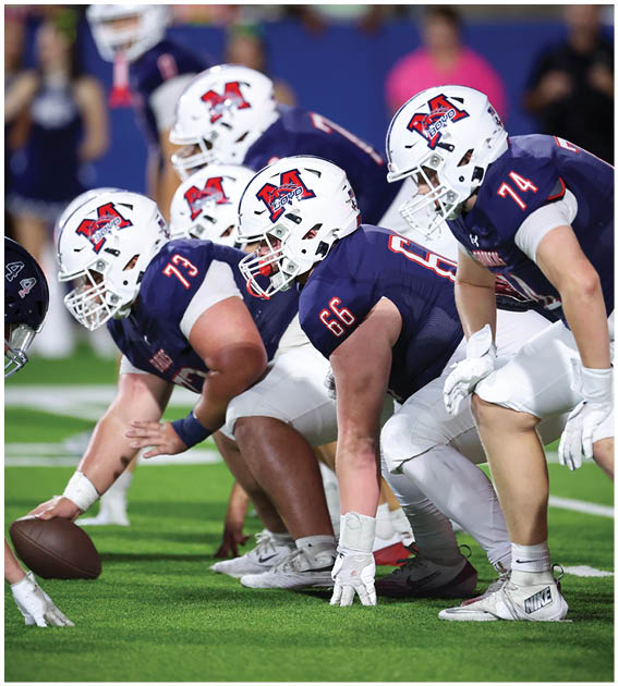 A group of football players wearing black and white uniforms. Description generated by AI