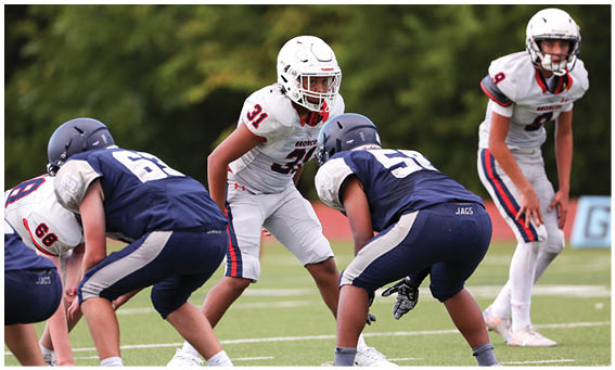 A group of football players on a field. Description generated by AI