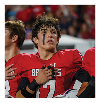A football player wearing a blue and red jersey. Description generated by AI